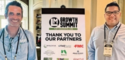 Two attendees posing with a sign thanking the partner companies